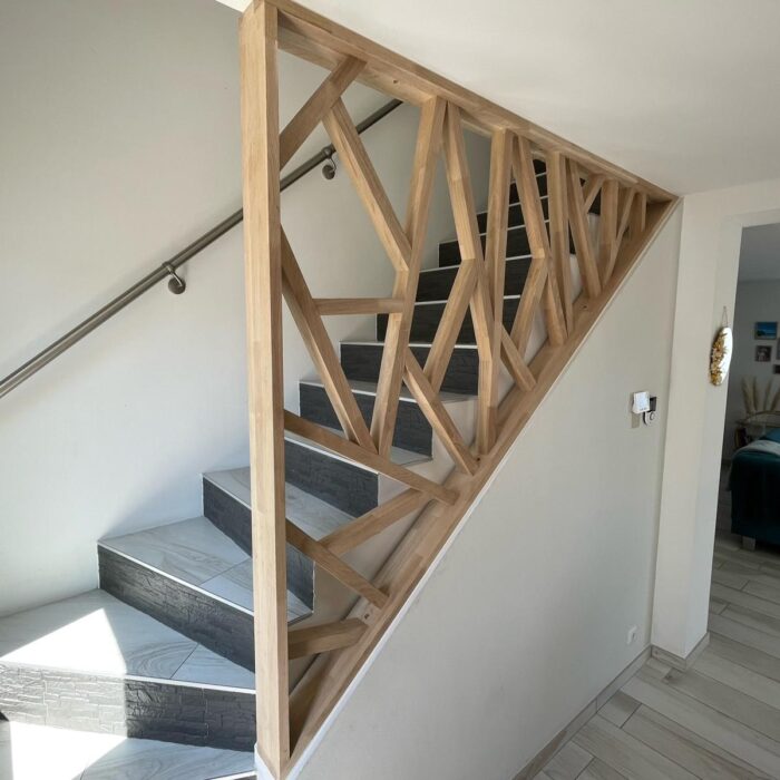 Garde-corps rampant en bois à motif géométrique le long d’un escalier