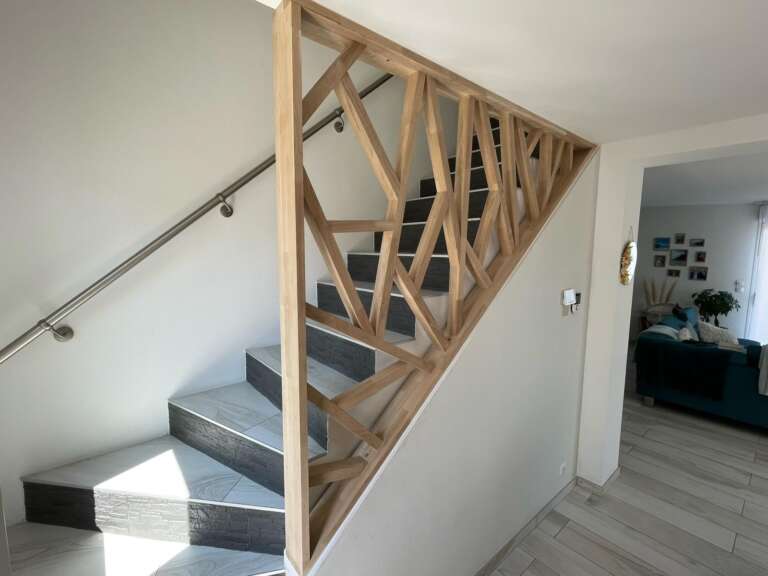 Garde-corps rampant en bois à motif géométrique le long d’un escalier