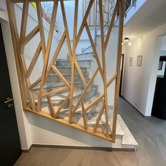 Garde-corps en bois à motif géométrique le long d’un escalier en pierre